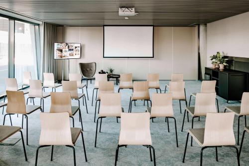 a conference room with chairs and a whiteboard at Vienna House by Wyndham Mokotow Warsaw in Warsaw