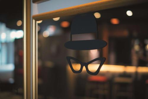 a pair of glasses and a hat in a window at Vienna House Easy by Wyndham Trier in Trier