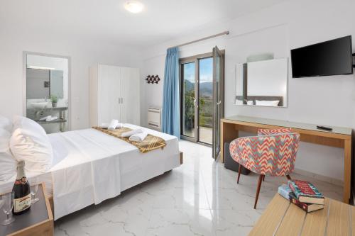 a bedroom with a bed and a desk and a chair at Fundana Villas in Liapades