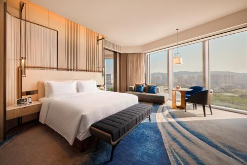 um quarto de hotel com uma cama e uma grande janela em Studio City - Epic Tower em Macau