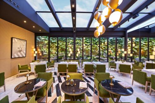 a restaurant with tables and chairs and large windows at Vakko Hotel and Residence in Istanbul