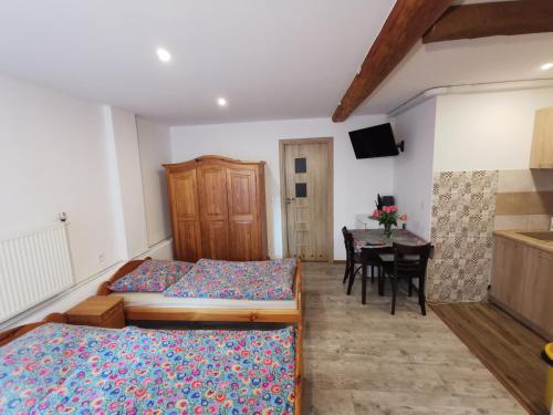 a bedroom with two beds and a dining room with a table at NOCLEGI POD STODOŁĄ in Kraków