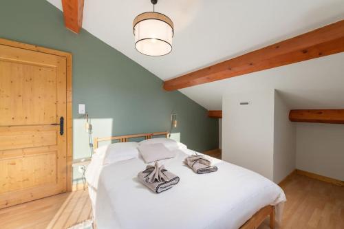 a bedroom with a large white bed with a ceiling at Le Cerf, chalet cocooning avec piscine et billard in Ban-sur-Meurthe-Clefcy