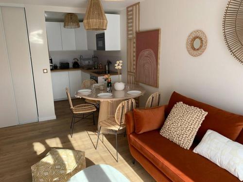 un salon avec un canapé et une table dans l'établissement Au temps retrouvé, à Cabourg