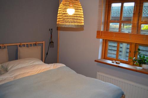 um quarto com uma cama, um candeeiro e uma janela em Holmgård em Süderholm