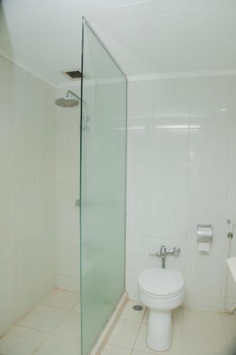 a bathroom with a toilet and a glass shower at Grand Inna Medan in Medan