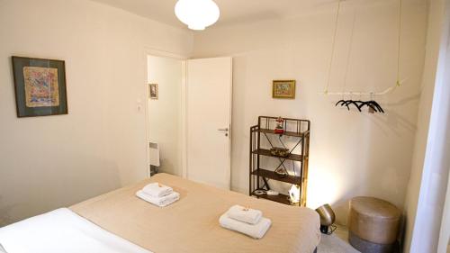 una camera da letto con due asciugamani seduti su un letto di quiet and central FLAT with private backyard GARDEN ad Atene