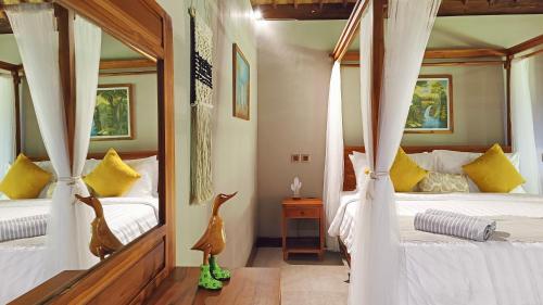 a bedroom with two beds and a mirror at Dalai Tropical in Kuta Lombok