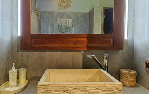 a wooden sink in a bathroom with a mirror at Dalai Tropical in Kuta Lombok