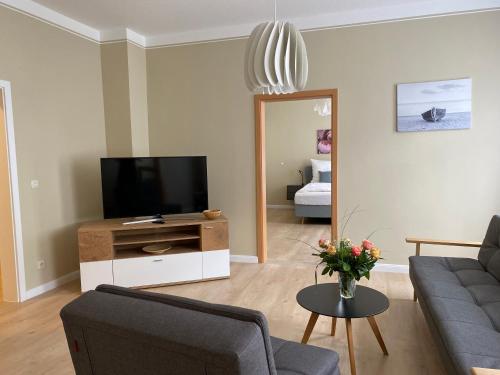 a living room with a couch and a tv at MOMENTS Ferienwohnungen - Goschwitzstraße 27 A in Bautzen