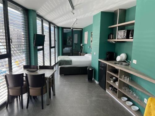 Habitación con cama, mesa y sillas. en PLAN B City Center Aparthotel, en Andorra la Vella