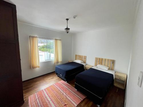 1 dormitorio con 2 camas y alfombra en Casaroma Hostels en Lima