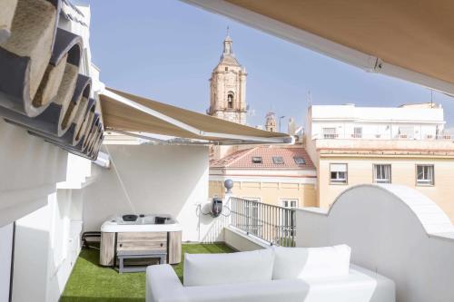 a balcony with white furniture and a view of a building at THE CLOCK HOUSE Luxury Urban Suites in Málaga