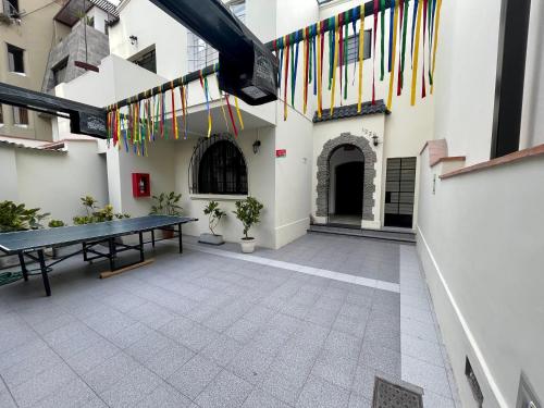 a ping pong table in the courtyard of a building with flags at Casaroma Hostels in Lima