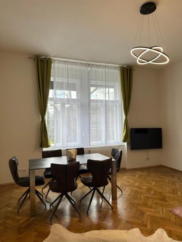 een woonkamer met een tafel en stoelen en een televisie bij ARTLIVING Apartment-Top 3 Self check-in in Graz