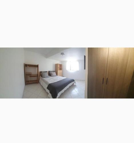 une chambre avec un lit et une armoire en bois dans l'établissement Appartement 2 pièces en rez de jardin de 60m2, à Peymeinade