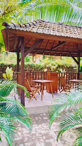 a wooden pavilion with a picnic table and chairs at Dalai Tropical in Kuta Lombok