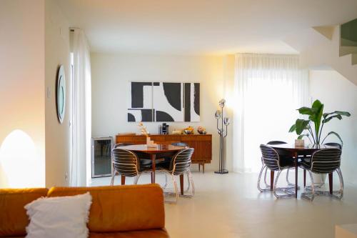 uma sala de estar com um sofá, uma mesa e cadeiras em Parisina Design Rooms em Pescara