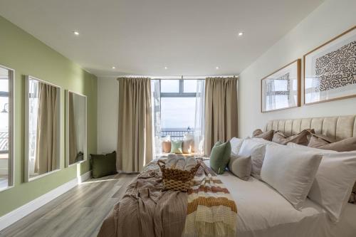a bedroom with a large bed and a large window at Luxury 1BR Seafront Apartment in Cardiff