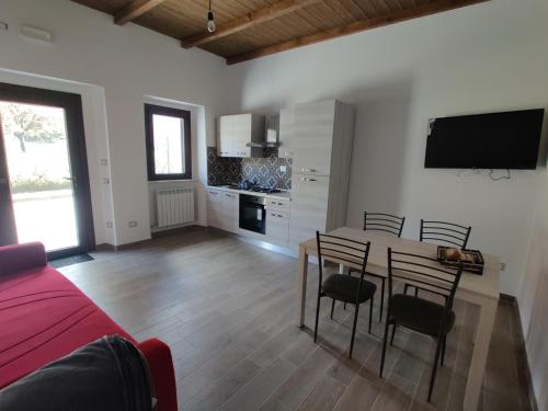 a living room with a table and chairs and a tv at La Dimora nella natura in Lecce neʼ Marsi