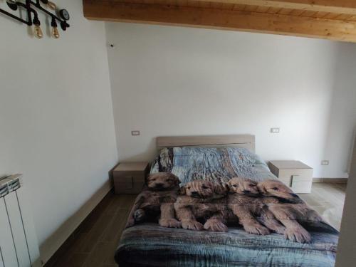 Un dormitorio con una cama con una manta. en La Dimora nella natura en Lecce neʼ Marsi
