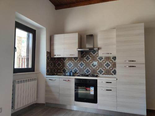 a kitchen with white cabinets and a stove at La Dimora nella natura in Lecce neʼ Marsi