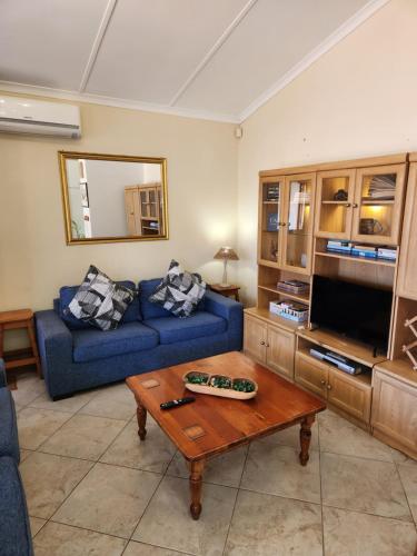 a living room with a blue couch and a coffee table at Aloe Self Catering in Port Shepstone