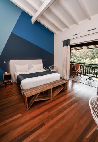 a bedroom with a bed and a blue wall at Hôtel Les Frères Ibarboure in Bidart