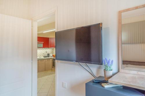 a large flat screen tv on a wall in a kitchen at Kanali Hill Apartment in (( Agía Eleoúsa ))