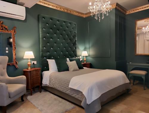 a green bedroom with a large bed and a chandelier at Julina Boutique Living in Mosta