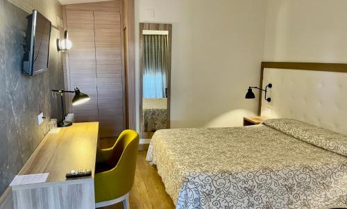 カネット・デ・ベレンゲルにあるHotel Playa Canetのベッドとデスクが備わるホテルルームです。