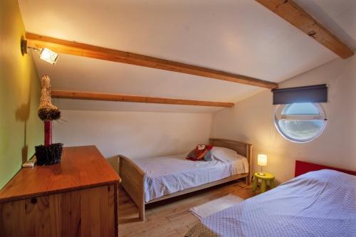1 dormitorio con 2 camas, mesa y ventana en Cote Conca Oro, en Barbaggio