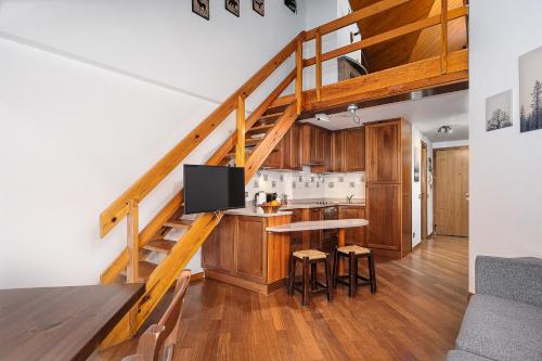 a living room with a kitchen and a staircase at Classbnb - Two apartments 500m from the skilifts in Breuil-Cervinia