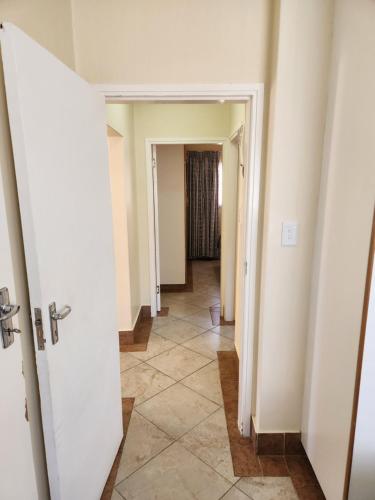 a hallway with white walls and a tile floor at Aloe Self Catering in Port Shepstone
