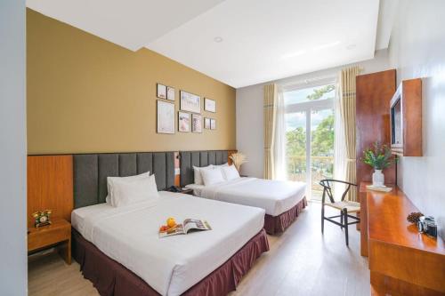 pokój hotelowy z 2 łóżkami i oknem w obiekcie Nature Hotel w mieście Da Lat