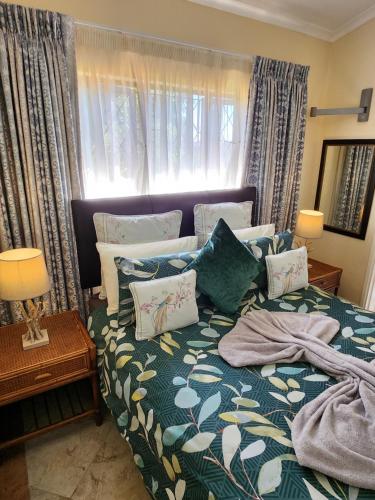 a bedroom with a bed with pillows on it at Aloe Self Catering in Port Shepstone