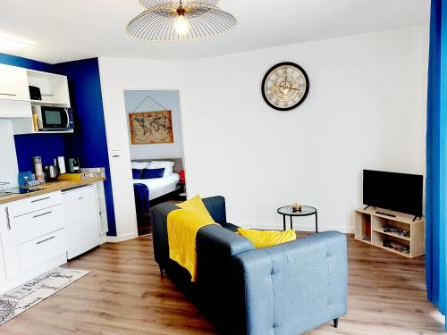 a living room with a couch and a clock on the wall at Appartement Résidentiel avec parking/Proche Centre in Angoulême