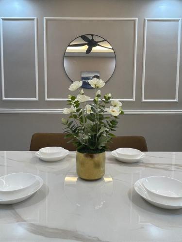 a table with a vase with white flowers on it at Homestay Cikgu Wanzarif@Bangi in Kampong Tangkas