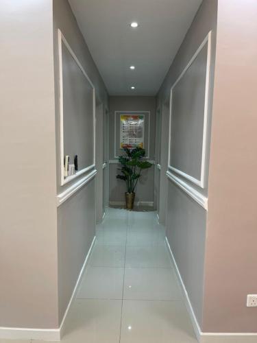 a hallway with white walls and a plant in it at Homestay Cikgu Wanzarif@Bangi in Kampong Tangkas