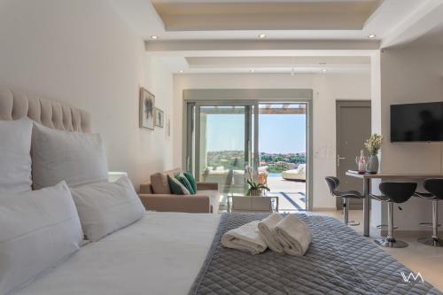 a bedroom with a bed with two towels on it at Villas Elini in Perdika