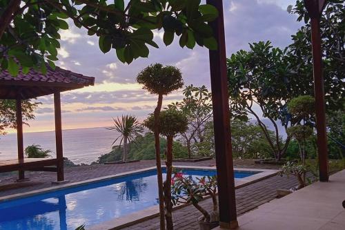 a resort swimming pool with a view of the ocean at Maluk House (1 bedroom) in Maluk