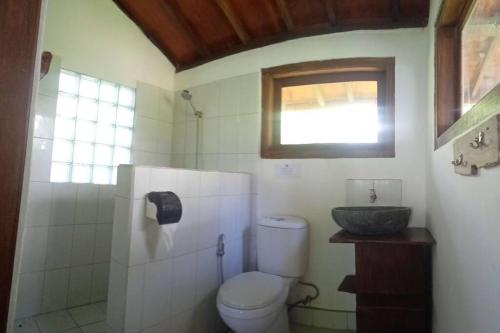 a bathroom with a toilet and a sink at Maluk House (1 bedroom) in Maluk