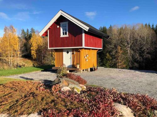 una pequeña casa roja y amarilla en una colina en Unik overnatting i Stabbur/Minihus en Lunde