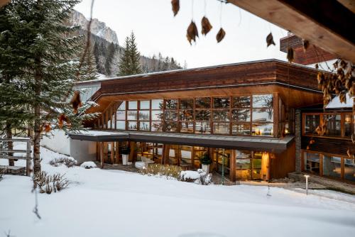 a house in the mountains with snow on the ground at Sporthotel Teresa in Badia
