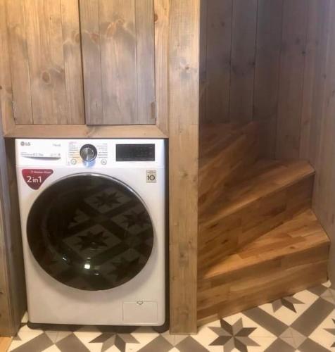 a washing machine sitting in a wooden cabinet at Unik overnatting i Stabbur/Minihus in Lunde