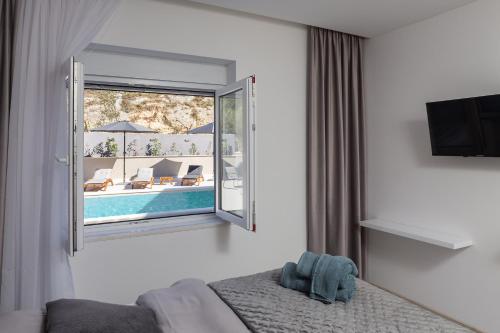 a bedroom with a window with a view of a pool at Luxury Apartment Lorena - Private Heated Pool - in Jesenice