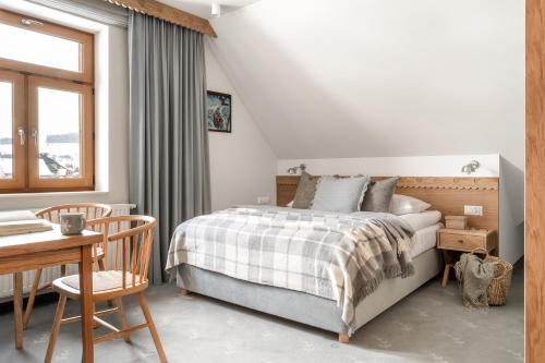 a bedroom with a bed and a table and a desk at W Dolinie Tylicza SPA & Wellness -gabinet masażu, saunarium-plac zabaw, rowery elektryczne, animacje dla dzieci in Krynica Zdrój