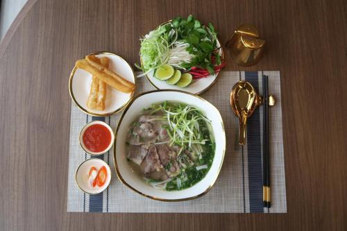 een tafel met twee borden eten en een kom soep bij Tam Coc Mandala Villa & Homestay in Ninh Binh
