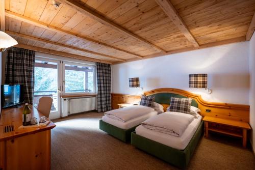 a large room with two beds and a television at Sporthotel Teresa in Badia