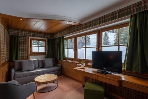a living room with a couch and a television at Sporthotel Teresa in Badia